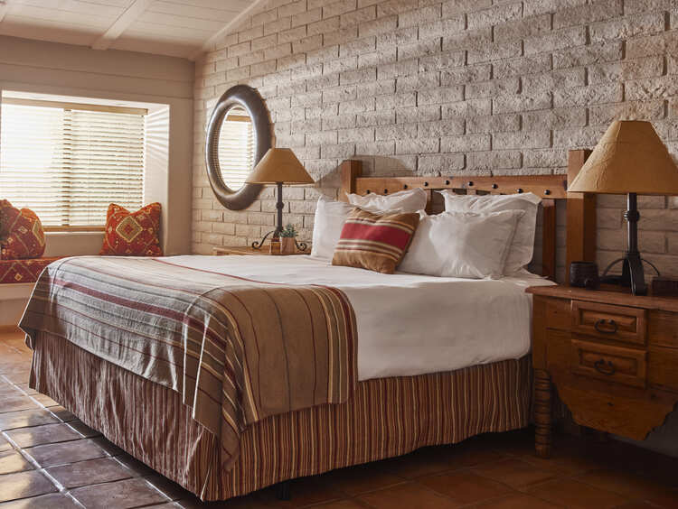 King bed with chair and sun beaming into room