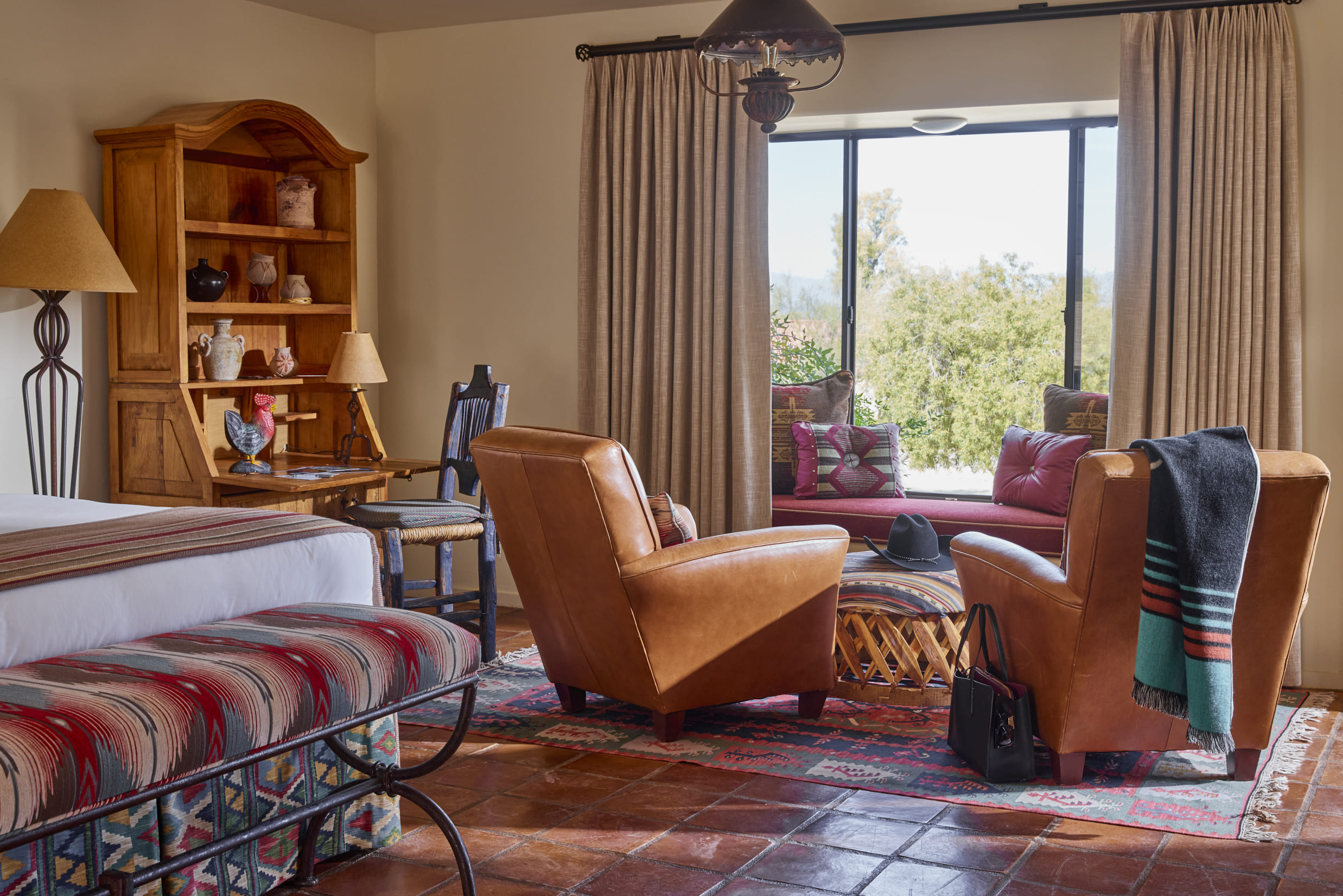 Double beds with red accent pillows and seat at end of bed